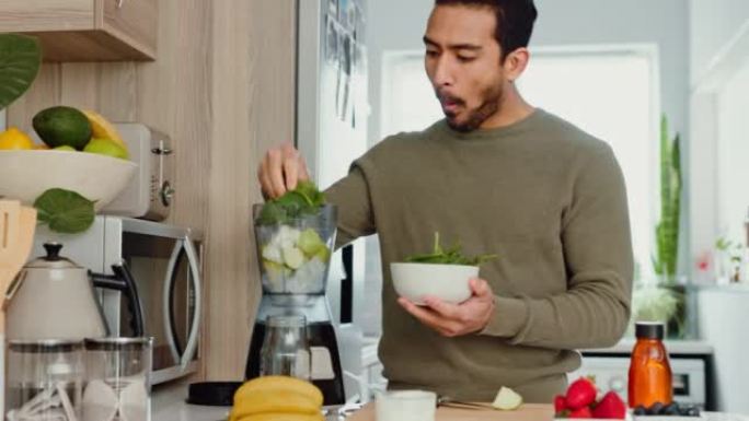 男人在厨房里用水果和蔬菜做健康的冰沙作为新鲜小吃。积极的生活方式始于良好的饮食习惯，饥饿时烹饪绿色食