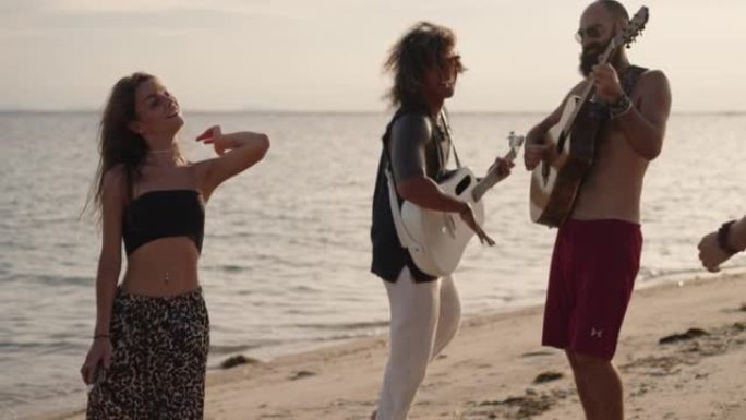朋友在沙滩上唱歌和弹吉他
