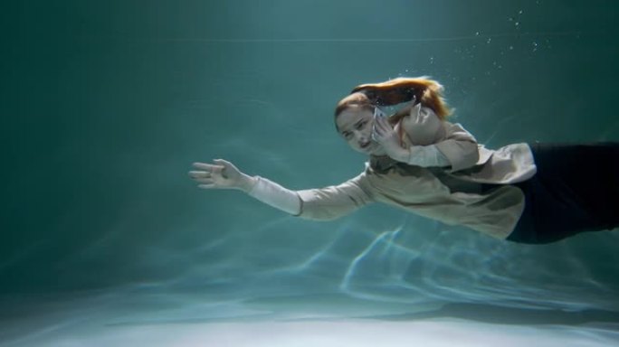 年轻快乐的女商人在电话上聊天的史诗电影镜头在水下游泳咨询客户慢动作