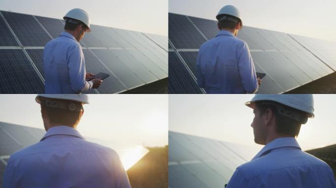 一位年轻的工程师正在用平板电脑检查日落时光伏太阳能电池板现场的阳光和清洁度。概念: 可再生能源、技术