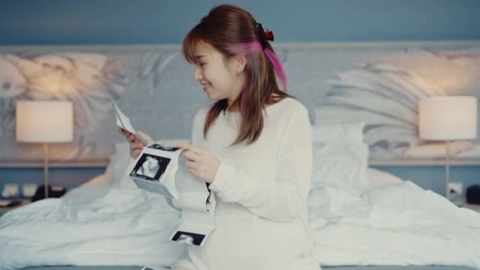 孕妇看着3D超声波扫描照片。