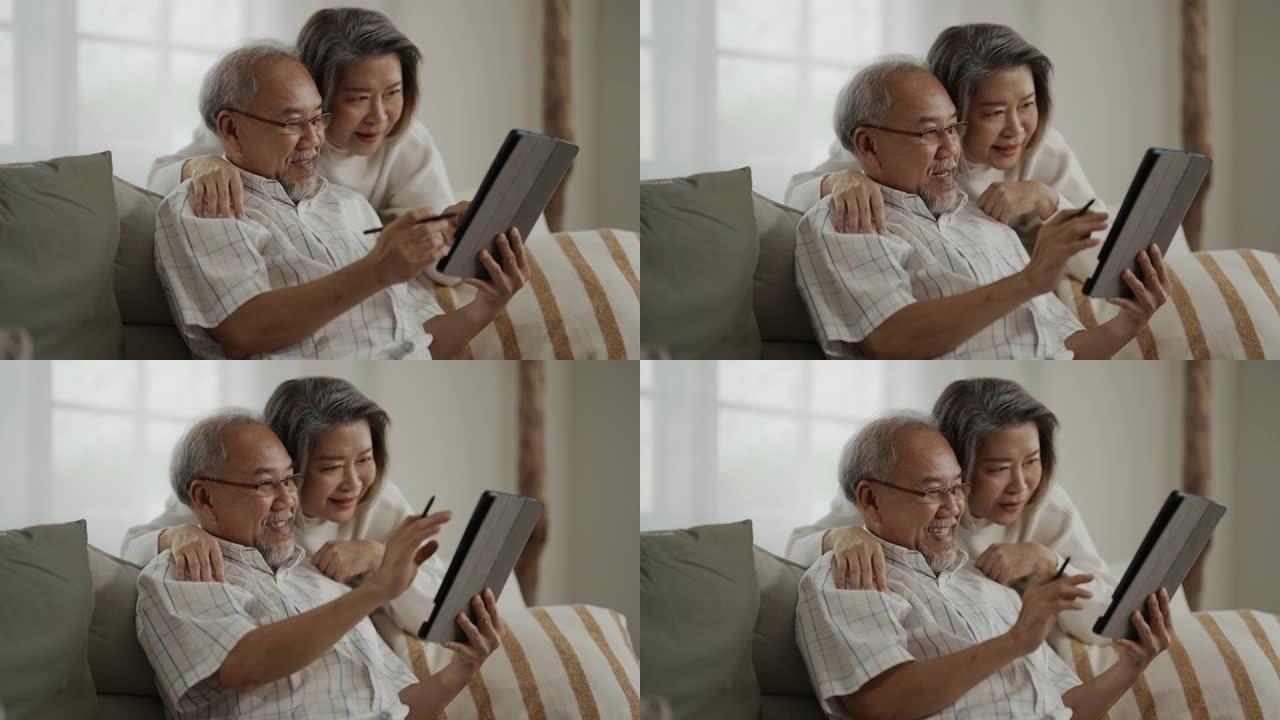 亚洲老年夫妇在家里一起使用数字平板电脑