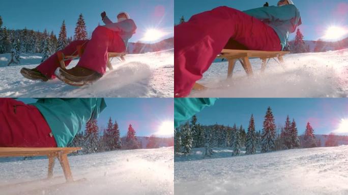 低角度: 在Kranjska Gora度假的开朗女人在雪山上雪橇。