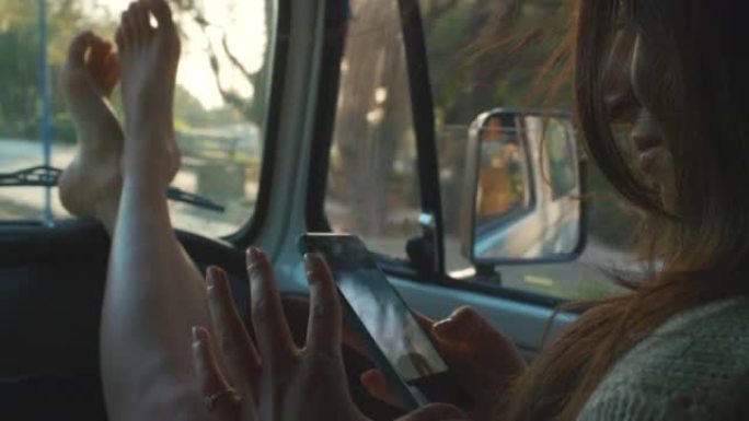 在意大利日落开车期间，一个无法识别的女人坐在汽车上并使用手机的4k视频片段