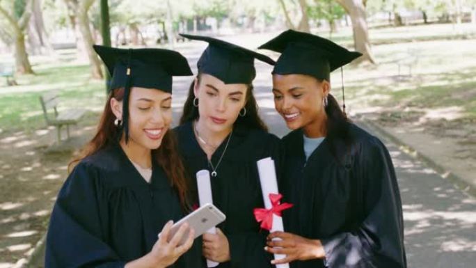 一群毕业生在大学校园毕业典礼后使用手机进行社交媒体自拍照。大学毕业后使用技术和持有学位的女性和朋友