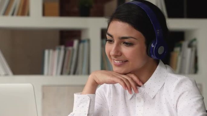 印度女人戴着耳机听音频课程学习英语