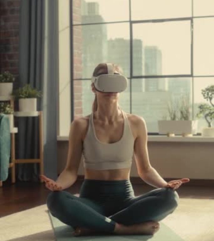 垂直肖像: 适合女性戴着虚拟现实耳机，在阳光明媚的阁楼公寓中以现代未来主义的方式练习冥想。健康的生活