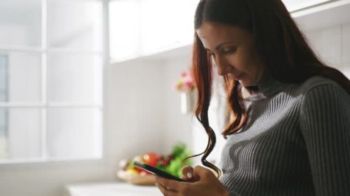 孕妇在家中使用智能手机发短信