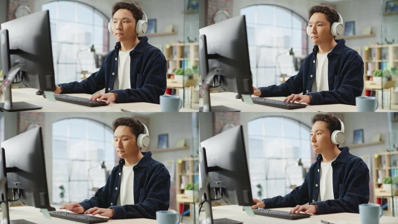 白天在现代办公室里用电脑工作的亚洲男性员工的肖像。客户支持代理在使用耳机时回答请求。手持镜头。