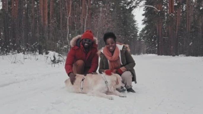与狗在雪地肖像上的情侣