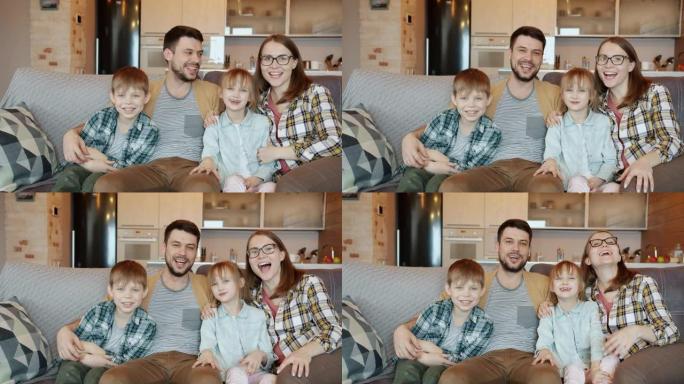 幸福家庭的肖像爸爸妈妈和孩子们看着电视说话和笑着看着相机