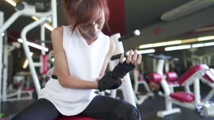 美丽的亚洲女子在健身房锻炼受伤