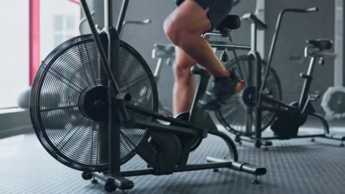 固定自行车，以及忙于锻炼和健身房腿部训练的女性的健身锻炼。运动员的强大运动，健康和健康有氧运动在健身