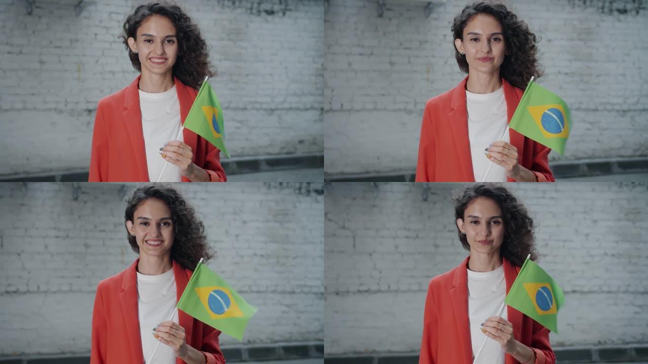 美丽的年轻女士游客站在户外，带着巴西国旗微笑的肖像