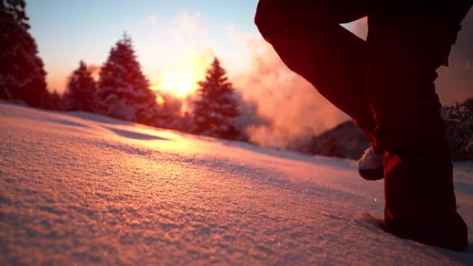 特写: 激动的女游客在日落时闪闪发光的新鲜粉末雪中奔跑。