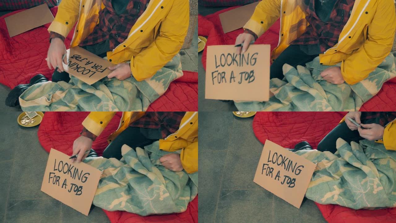 一个无家可归的人正在盘子上写他正在找工作