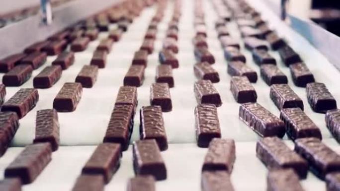 特写镜头中带有巧克力糖果棒的传送带