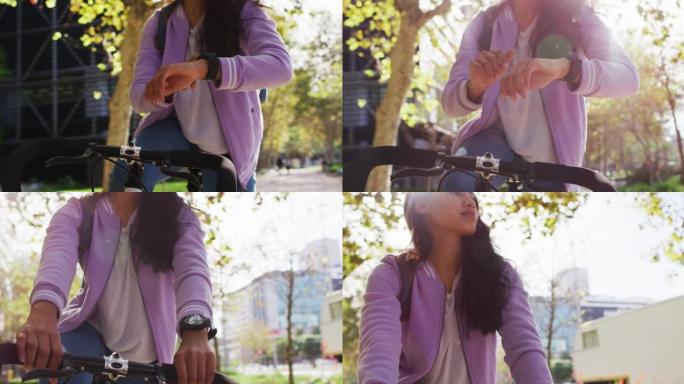 亚洲妇女坐在公园里骑自行车时使用智能手表