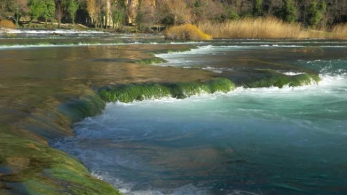 特写: 克尔卡河的自然美景流过绿色杂草丛生的小瀑布