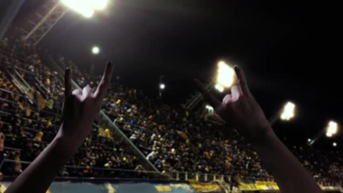 在足球场上，女性手举着魔鬼角手势。