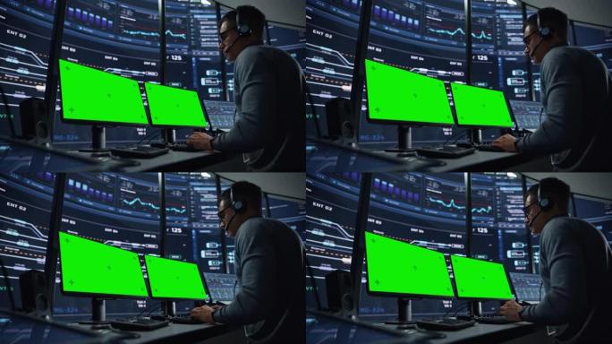 专业的信息技术技术支持专家和软件开发人员在数字屏幕监控控制室的绿屏模拟显示计算机上工作。员工戴着耳机