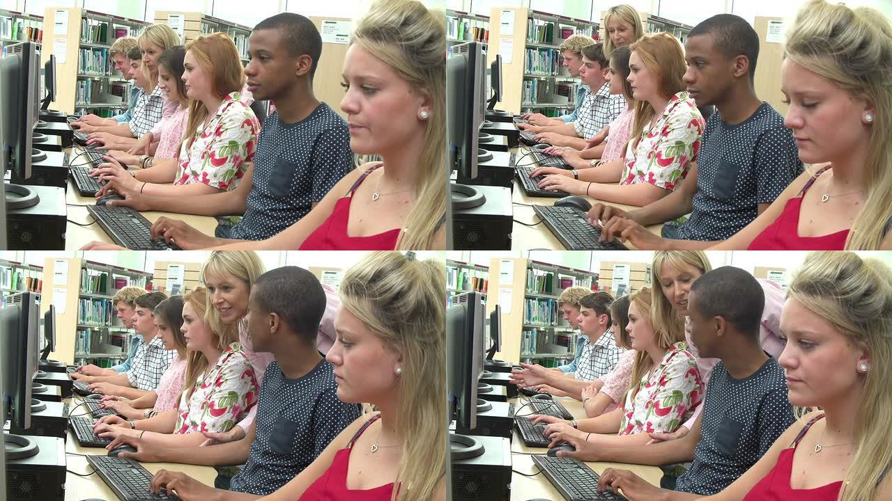 与老师一起在图书馆的计算机上工作的学生