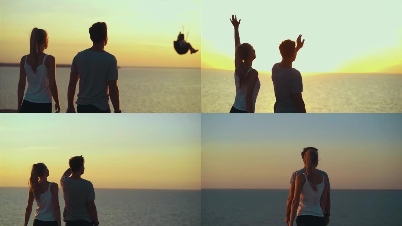 幸福的夫妇在海边看着滑翔伞。慢动作