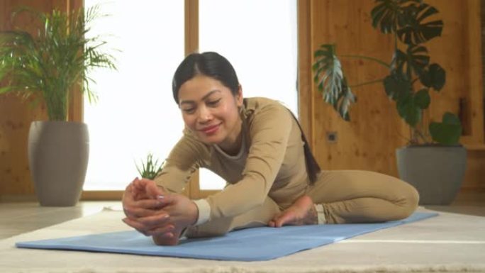 肖像: 亚洲女子微笑着表演坐姿向前折叠瑜伽姿势
