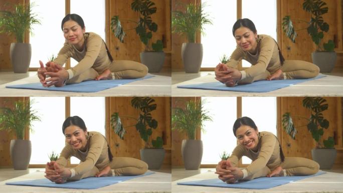肖像: 亚洲女子微笑着表演坐姿向前折叠瑜伽姿势