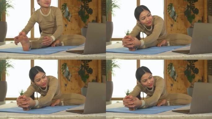 特写: 亚洲女性接受在线瑜伽训练并练习坐姿