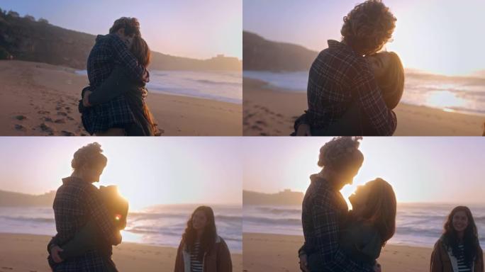 日落时在海滩上拥抱的年轻夫妇