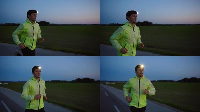 慢动作，跟踪拍摄黄昏时在高速公路上跑步的男运动员，穿着反光运动服和头灯