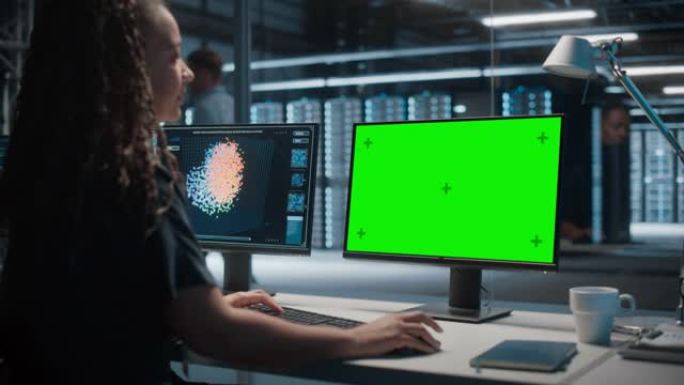 高科技数据中心服务器: 黑色女性IT专家在绿屏色度关键计算机上工作。监控网络服务、云计算、分析设施、