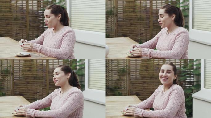 4k视频片段，一名年轻女子在家里的花园里独自一人在外面喝茶