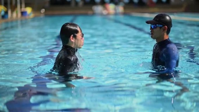 慢动作亚洲中国游泳教练在游泳便便中拥抱他的学生
