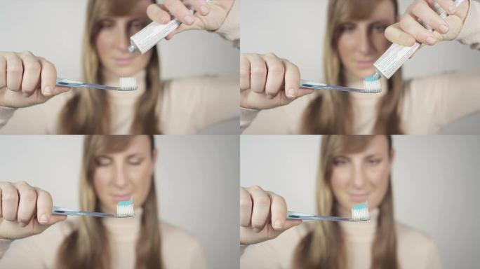 女性将牙膏挤到牙刷上