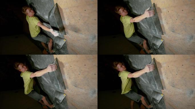 特写: 登山者在抱石健身房训练时伸手抓住。