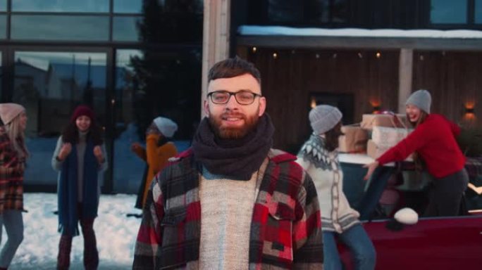 在圣诞朋友派对慢动作上，穿着冬装的20多岁白种人快乐微笑的肖像在相机前摆姿势。