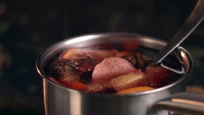 钢制平底锅，在其中煮熟带有橙子，苹果和肉桂的热酒
