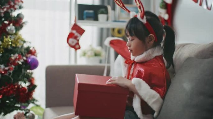 亚洲女孩在圣诞节打开礼品盒