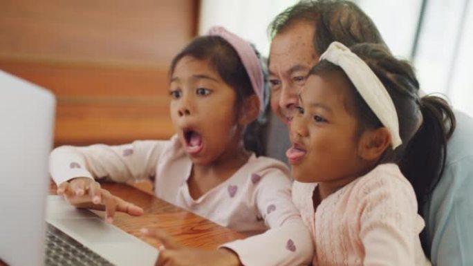 孩子或孩子拉着傻脸，与祖父结伴，拍照。可爱的孙子们和他们的祖父一起用笔记本电脑在社交媒体上发帖有趣的