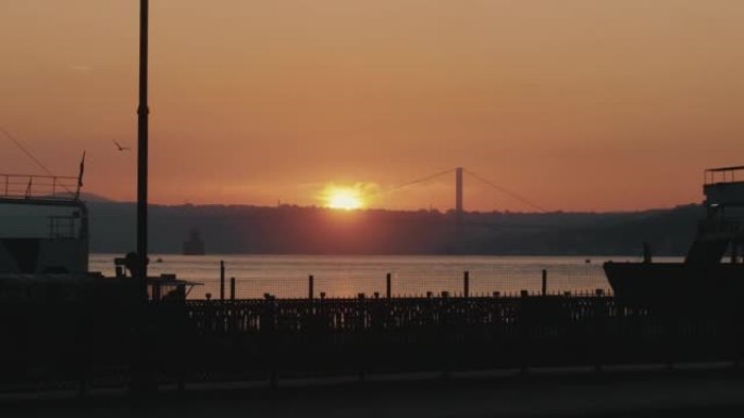 宁静的背景拍摄橙色日落在平静的海滨码头风景，壮丽的海洋日落全景。