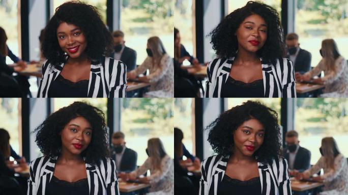 令人惊叹的肖像年轻美丽的非洲女企业家微笑着摆姿势在轻办公室慢动作。