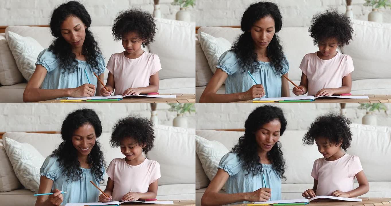 非洲母亲和女儿在素描本中与铅笔一起绘画