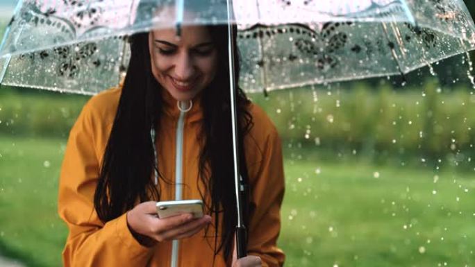超级SLO MO年轻女子在雨中使用智能手机时微笑