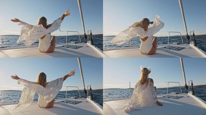 SLO MO年轻女子在帆船甲板上享受微风时举起双手