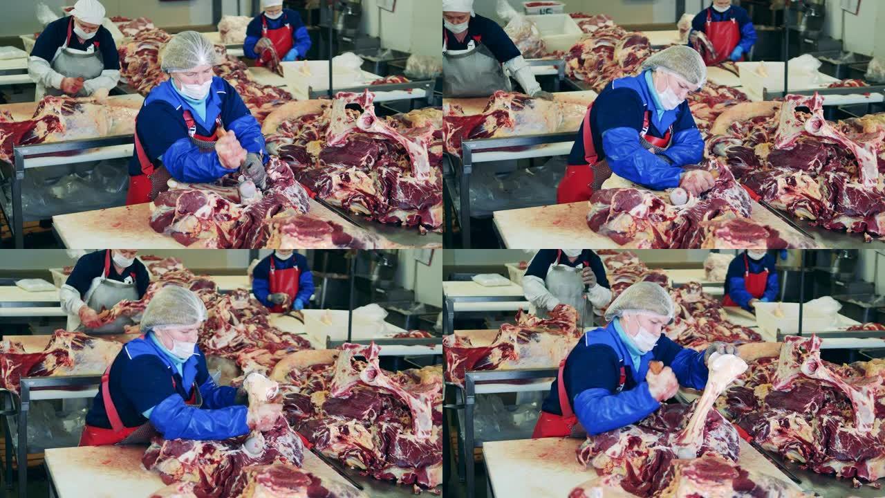 妇女在肉类包装厂切猪肉。