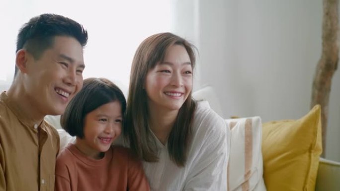 带着女儿微笑的亚洲家庭看着镜头