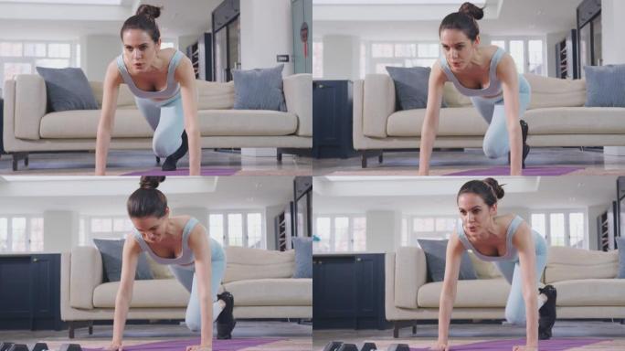 穿着健身服装的女人在休息室里做伸展运动，用手举重锻炼