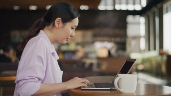 女人在咖啡店使用笔记本电脑